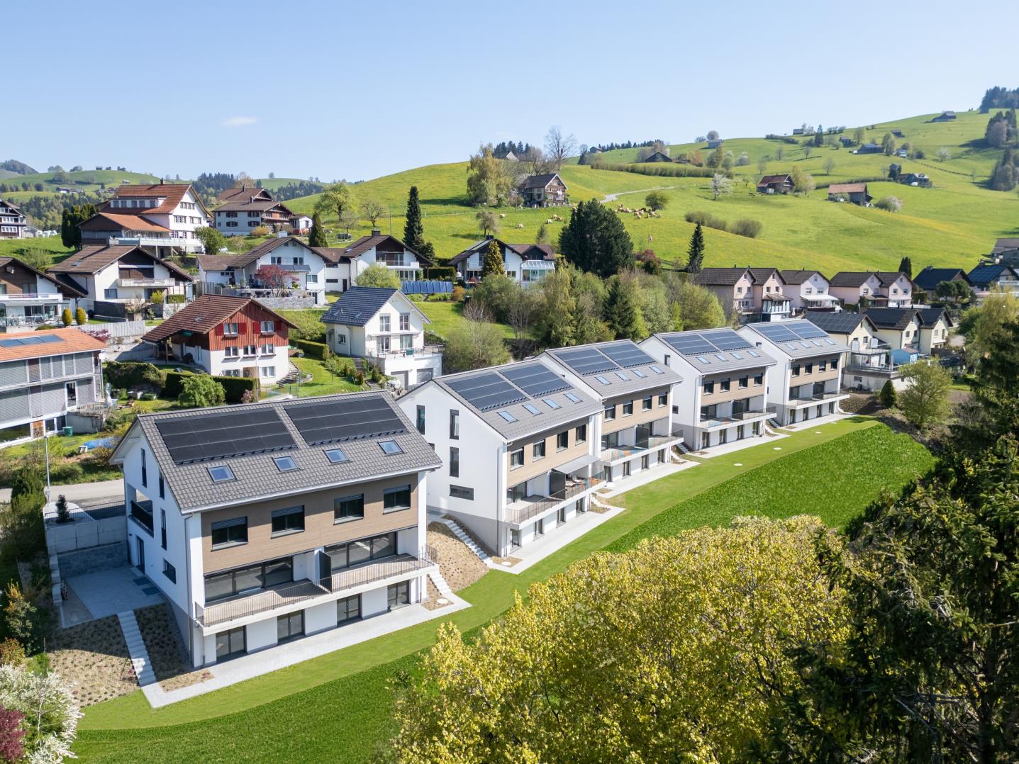 Luftaufnahme moderner Wohnanlage in grüner Hügellandschaft