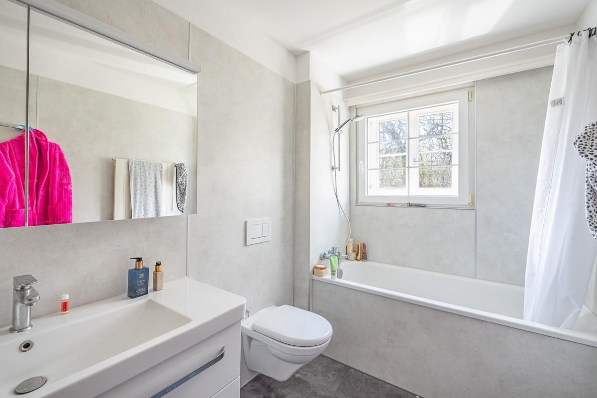 Modernes Badezimmer mit Wanne und Fenster