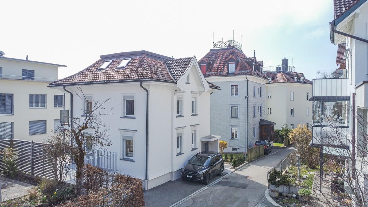 Wohnhäuser mit Satteldächern an einer schmalen Zufahrtsstraße