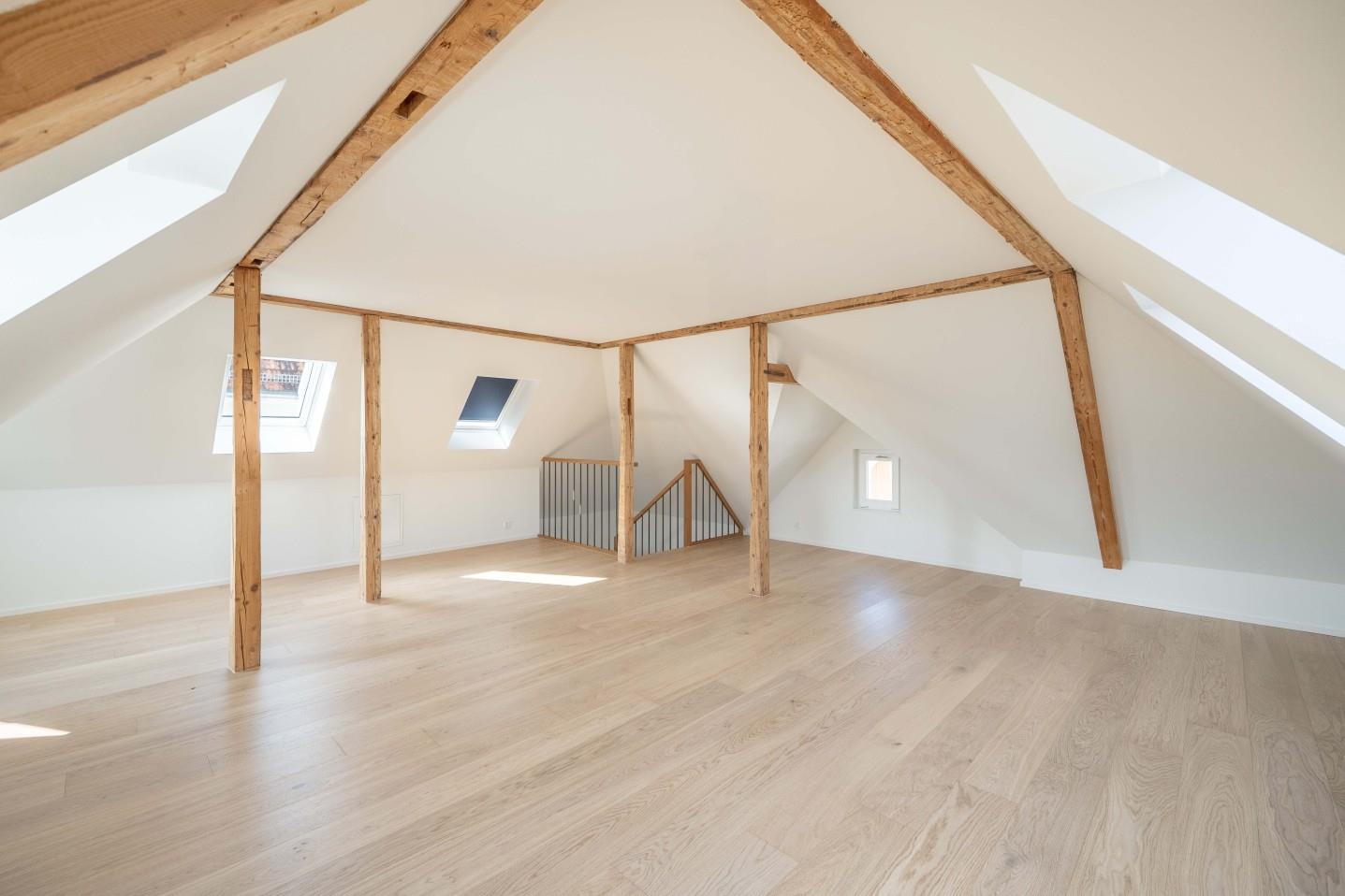Ausgebauter Dachboden mit sichtbaren Holzbalken
