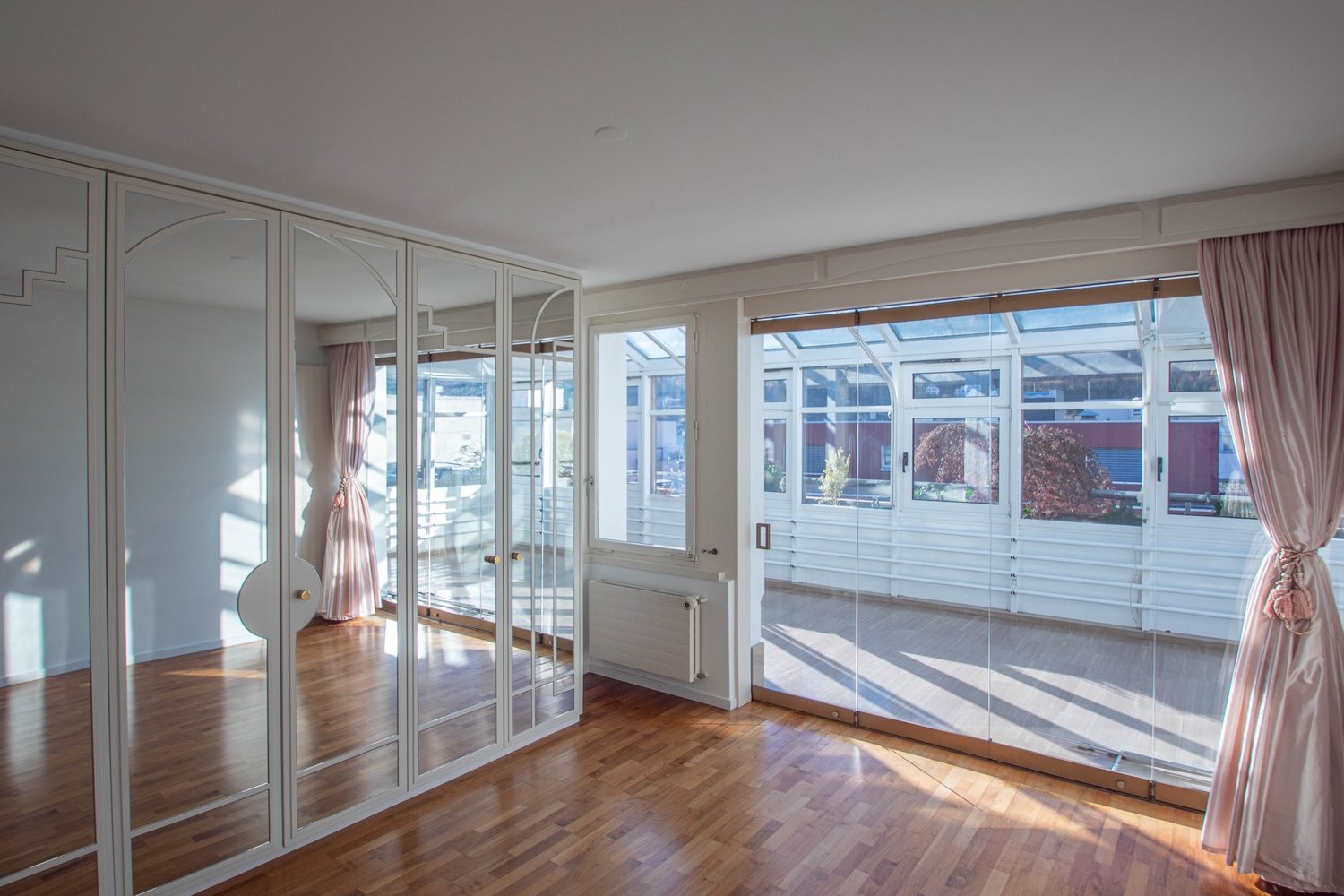 Heller Wintergarten mit Spiegelkleiderschrank