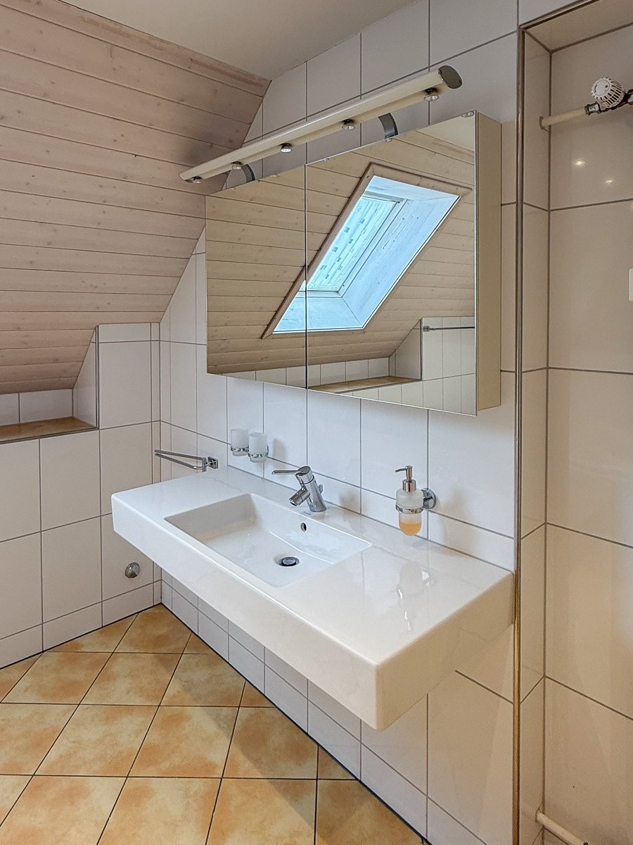 Dachgeschoss-Badezimmer mit Waschtisch und Dachfenster