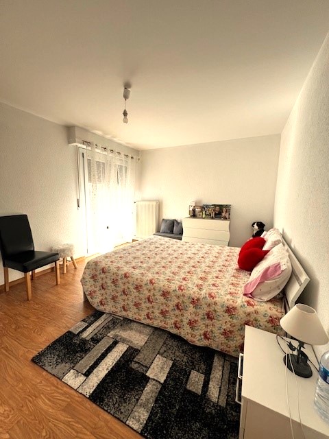 Helles Schlafzimmer mit Doppelbett und Fenster