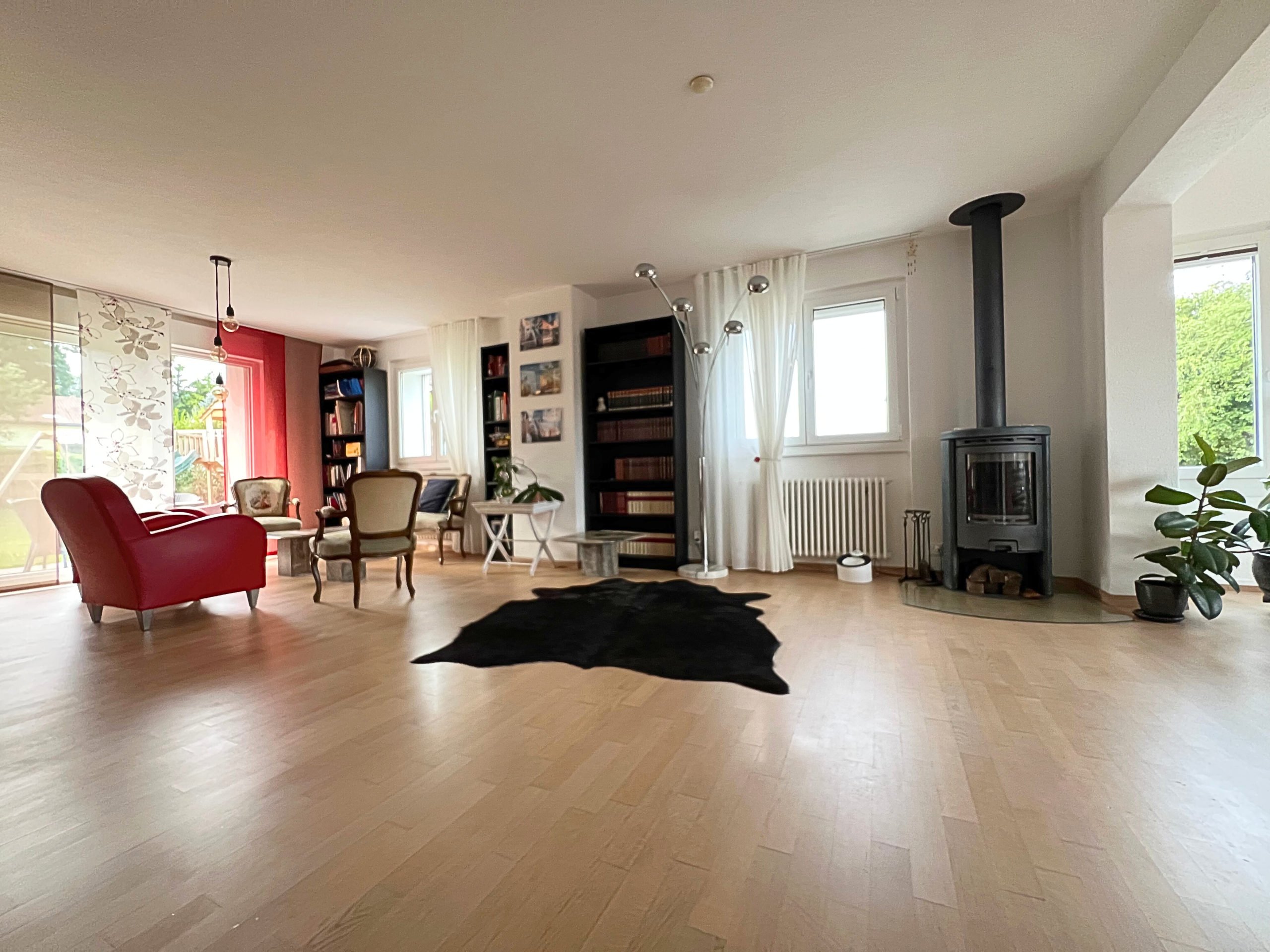 Helles Wohn- und Kaminzimmer mit großen Fenstern