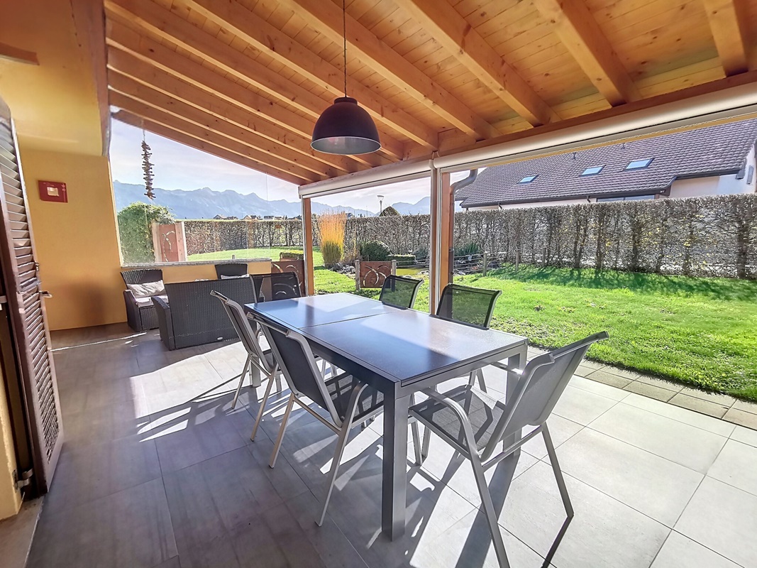Überdachte Terrasse mit Essbereich und Gartenblick