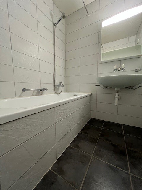 Badezimmer mit Badewanne und Wandwaschbecken