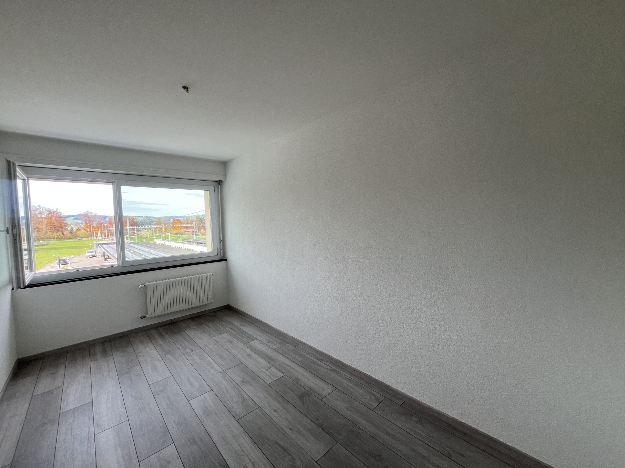 Leerer heller Raum mit Fenster und Heizkörper