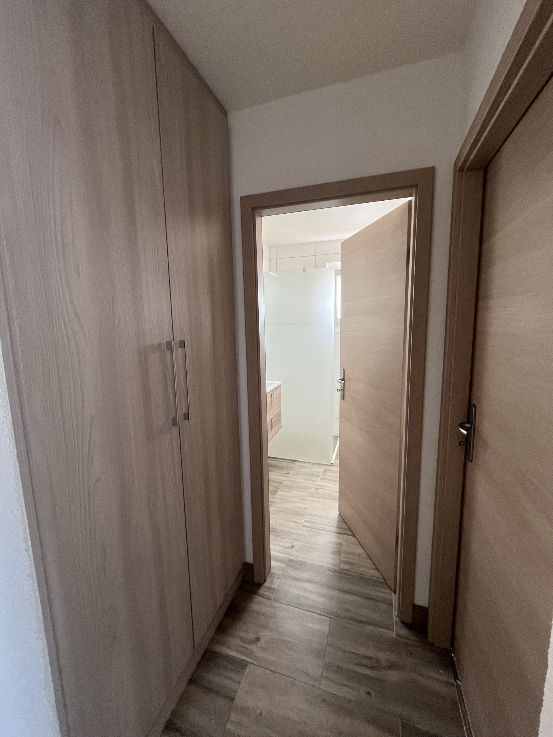Flur mit Einbauschränken und Blick ins Bad