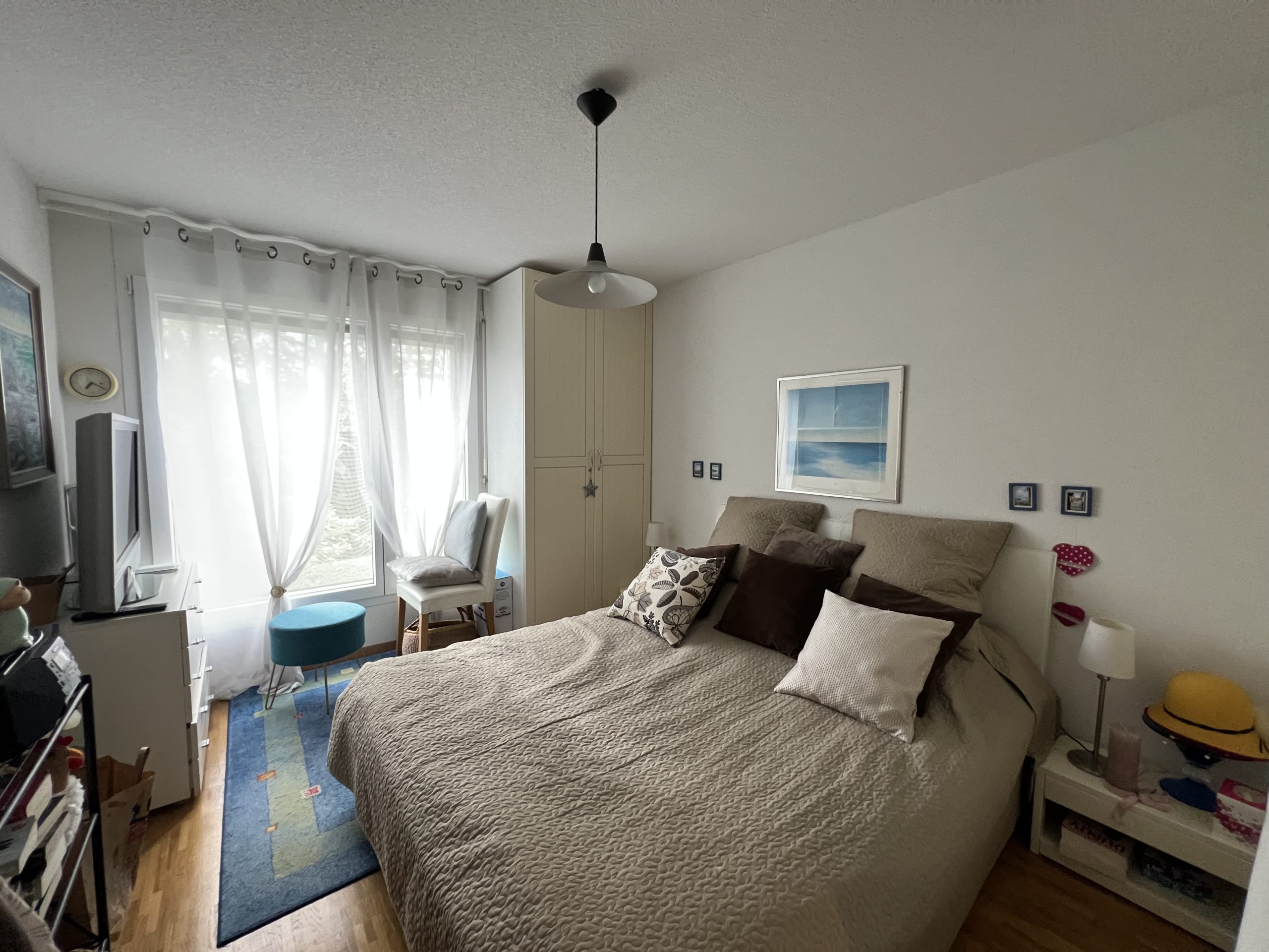 Helles Schlafzimmer mit Bett und Fensterbereich