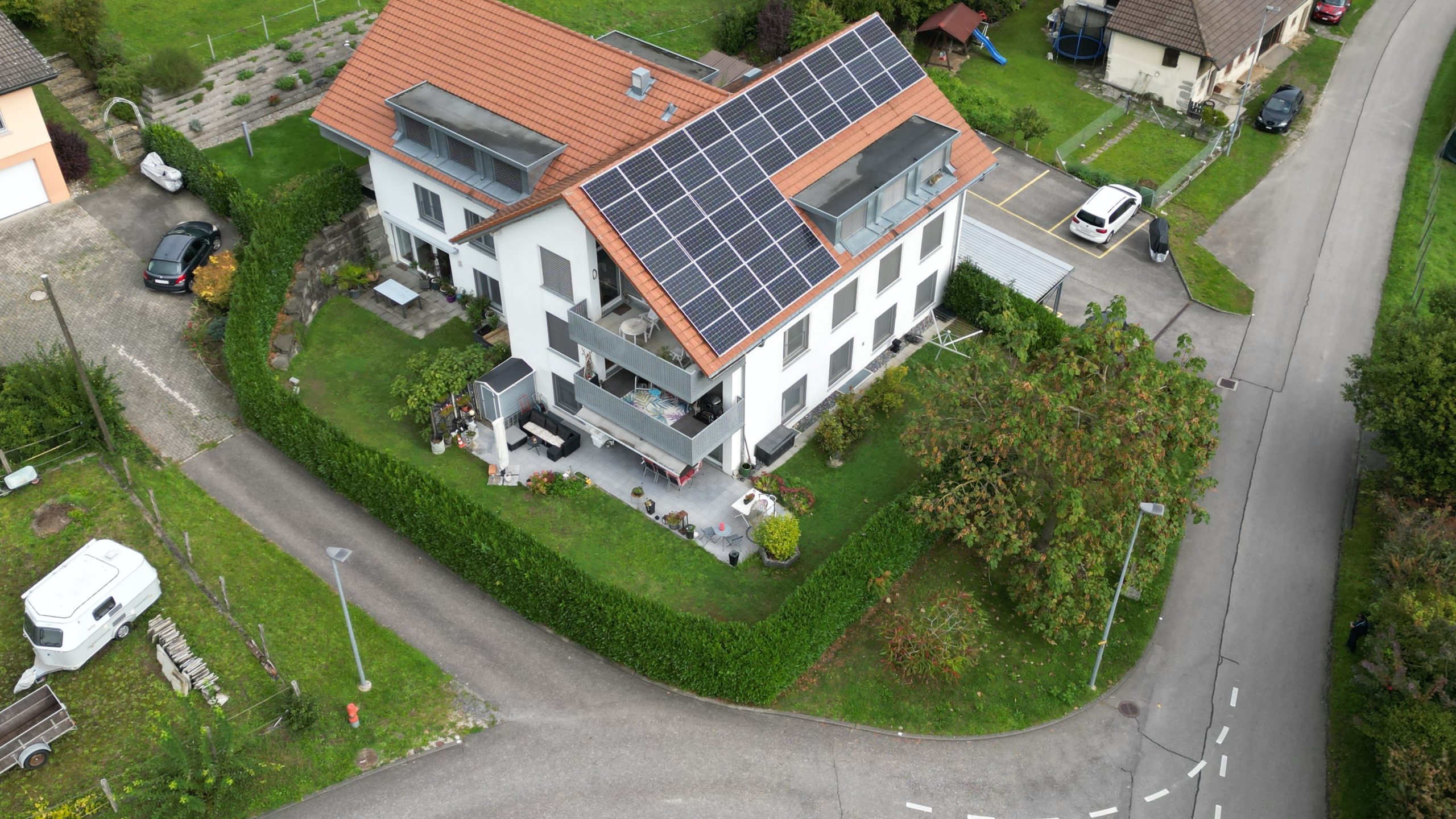 Auffälliges Einfamilienhaus mit Solarzellen und Garten aus der Vogelperspektive