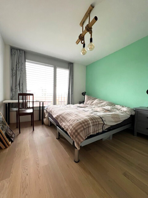 Schlafzimmer mit großem Fenster und Doppelbett