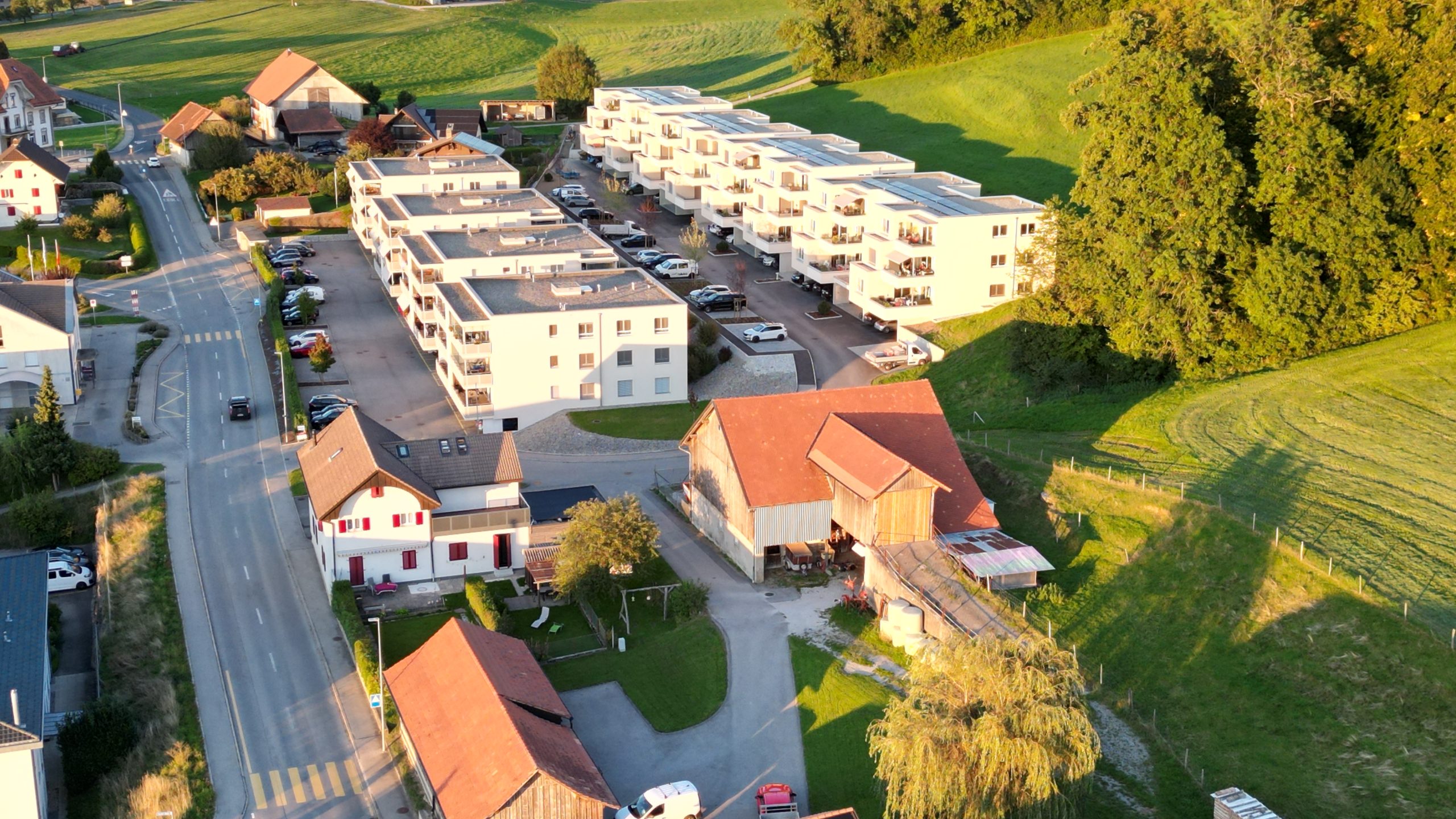 Luftaufnahme eines Wohnquartiers mit Mehrfamilienhäusern und Landschaft