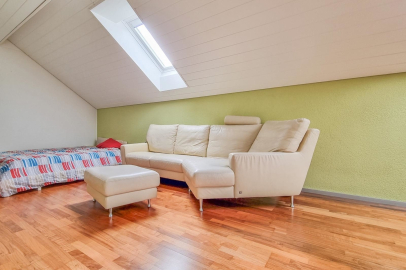 Helles Dachzimmer mit Sofa und Ottomane