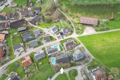 Luftaufnahme eines Wohngebiets mit Einfamilienhäusern und Grünflächen