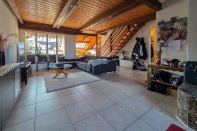 Heller Wohnbereich mit Holzdecke und offener Treppe