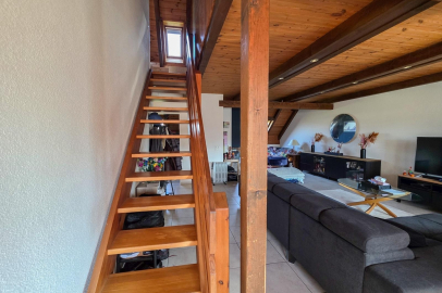 Wohnbereich mit Holztreppe und sichtbarer Dachkonstruktion