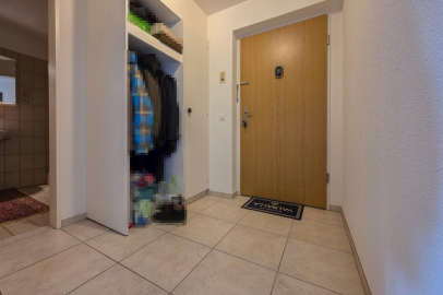 Heller Eingangsbereich mit Holztür und Garderobe