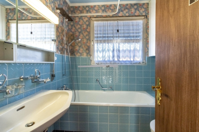 Badezimmer mit Badewanne und blau gefliesten Wänden