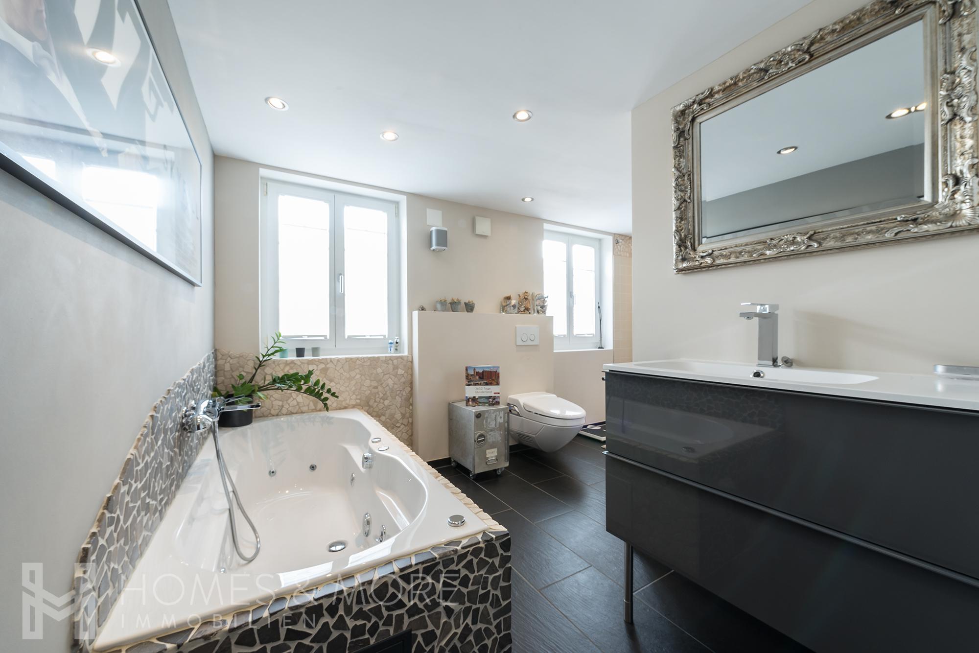 Modernes Badezimmer mit Whirlpoolwanne und Doppelwaschtisch