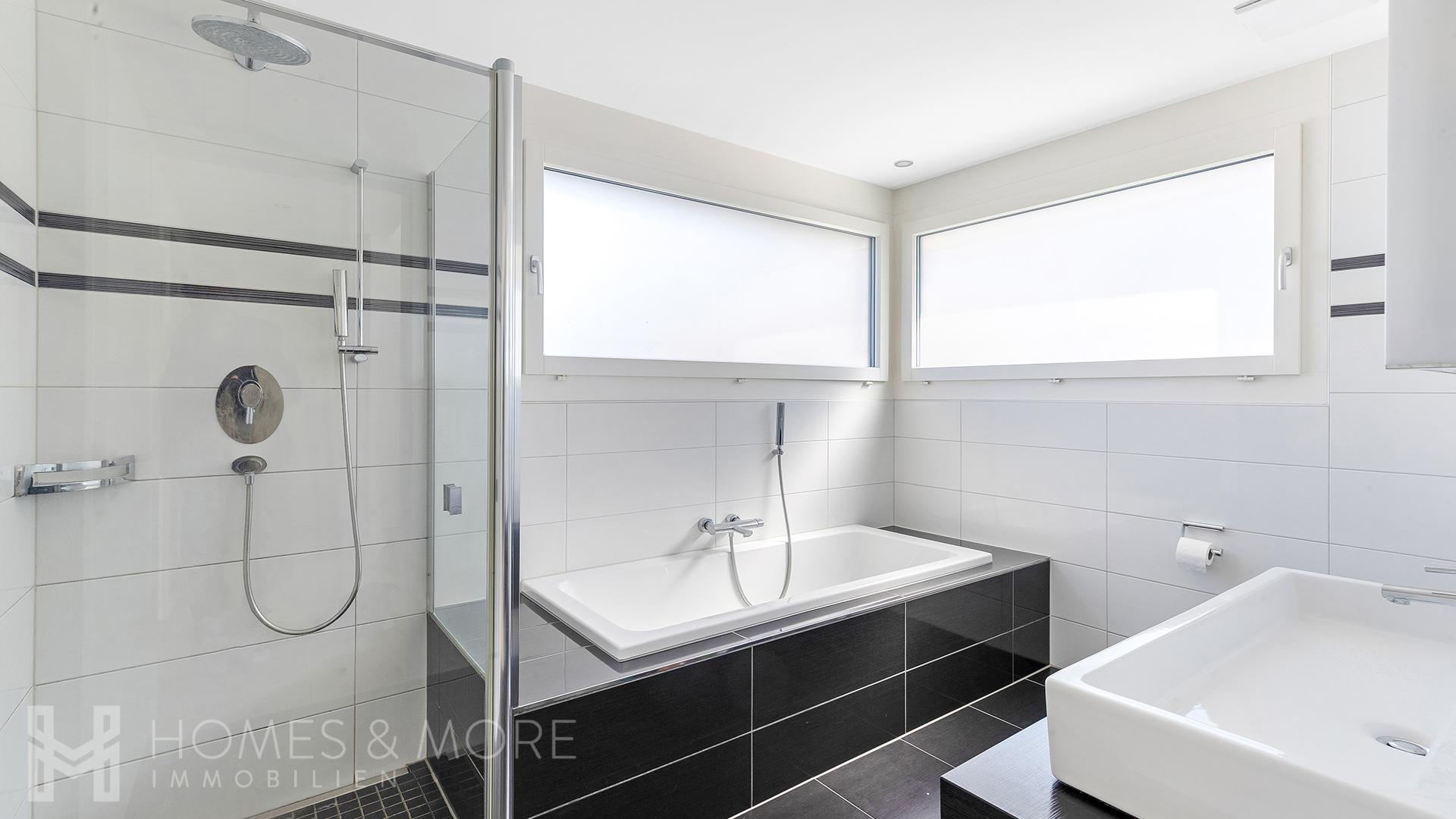 Modernes Bad mit bodentiefer Dusche und Badewanne