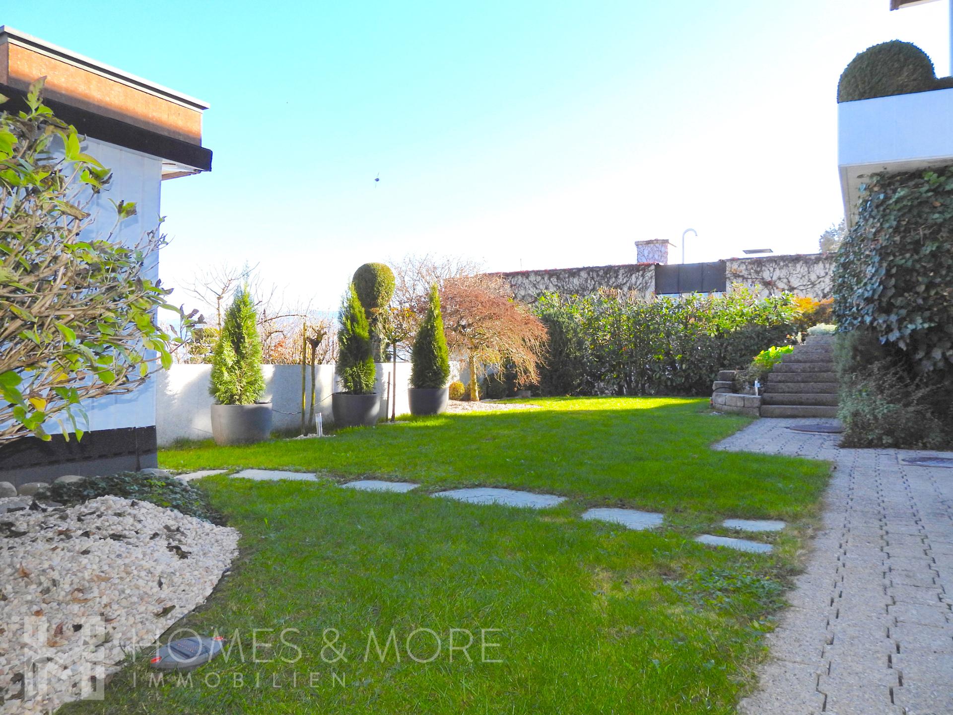 Gepflegter Garten mit Terrasse und Wegplatten