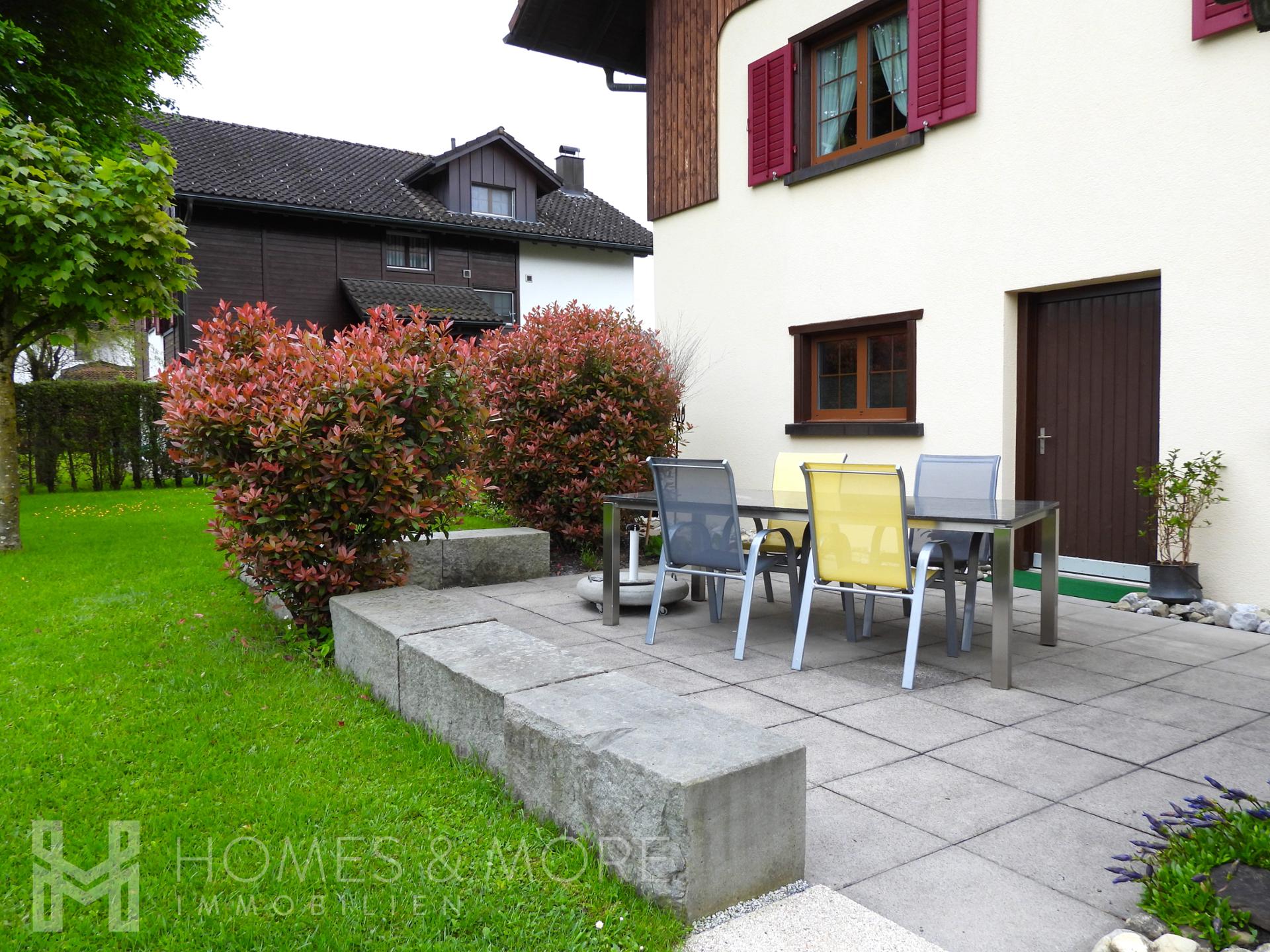 Terrasse mit Gartenmöbeln vor einem Wohnhaus