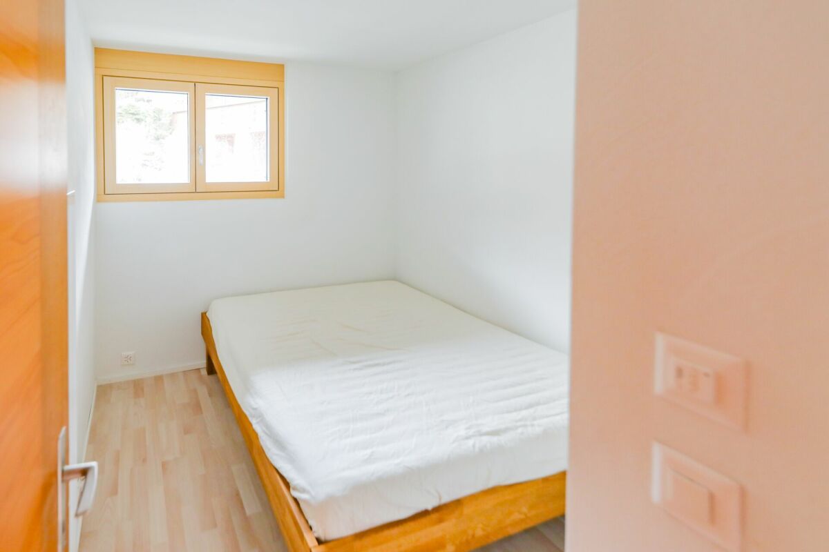 Kleines Schlafzimmer mit Bett und Fenster