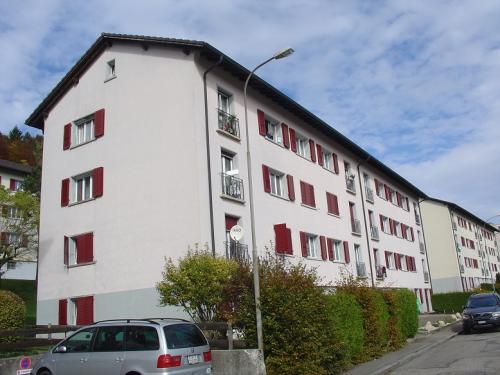Mehrfamilienhaus mit roten Fensterläden