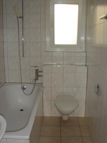 Kleines innenliegendes Badezimmer mit Wanne und WC