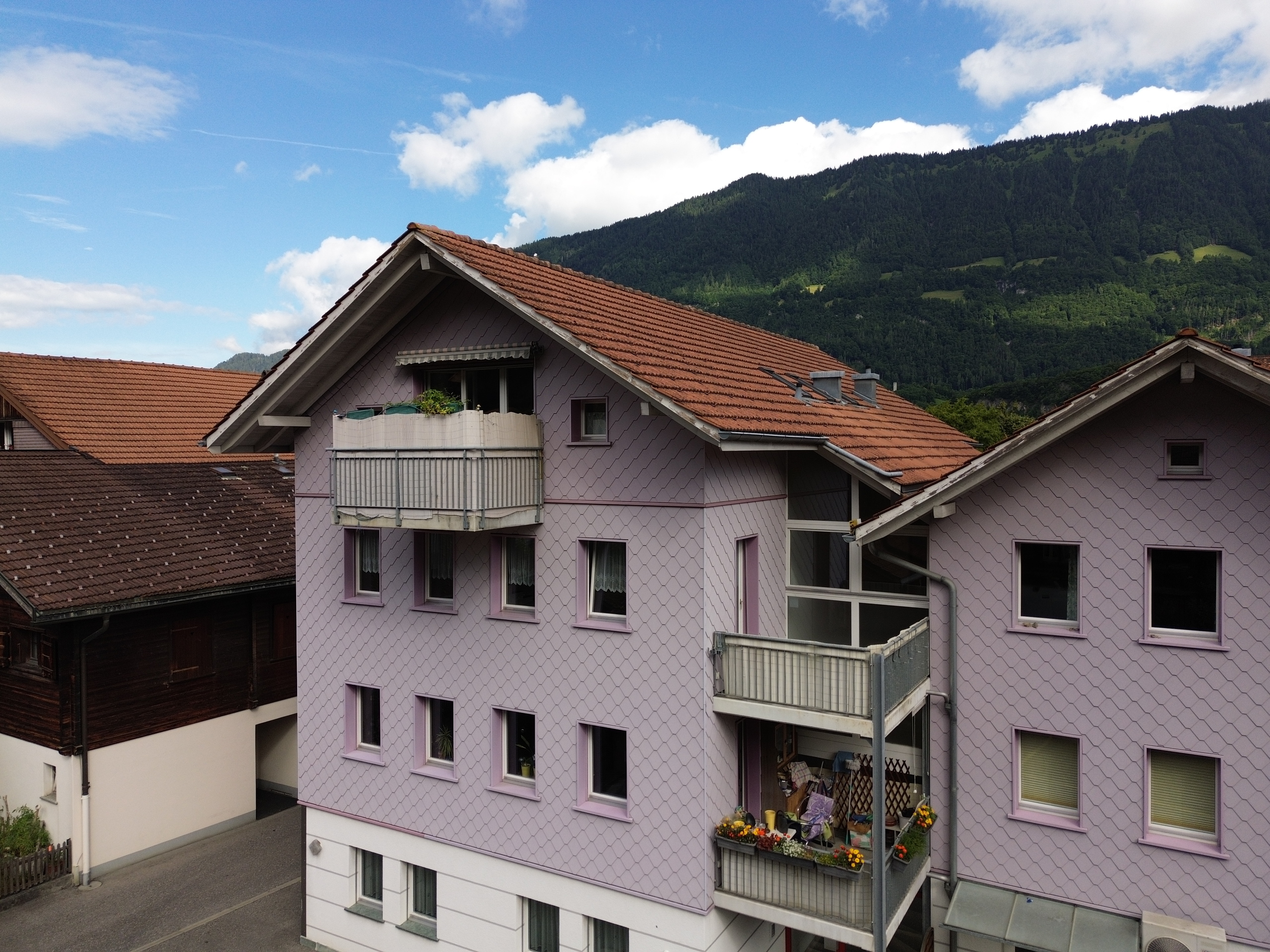Wohnhaus mit Balkon vor Bergkulisse