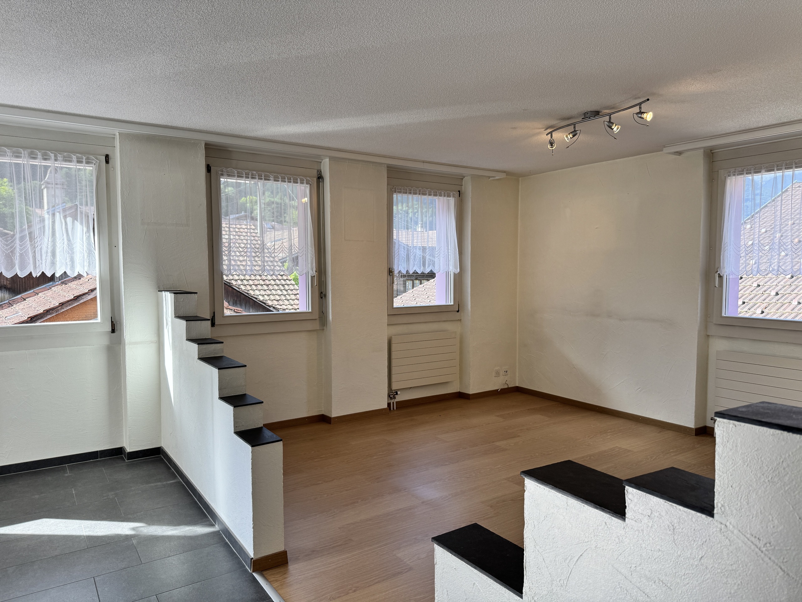 Heller Wohnraum mit Fenstern und Treppe