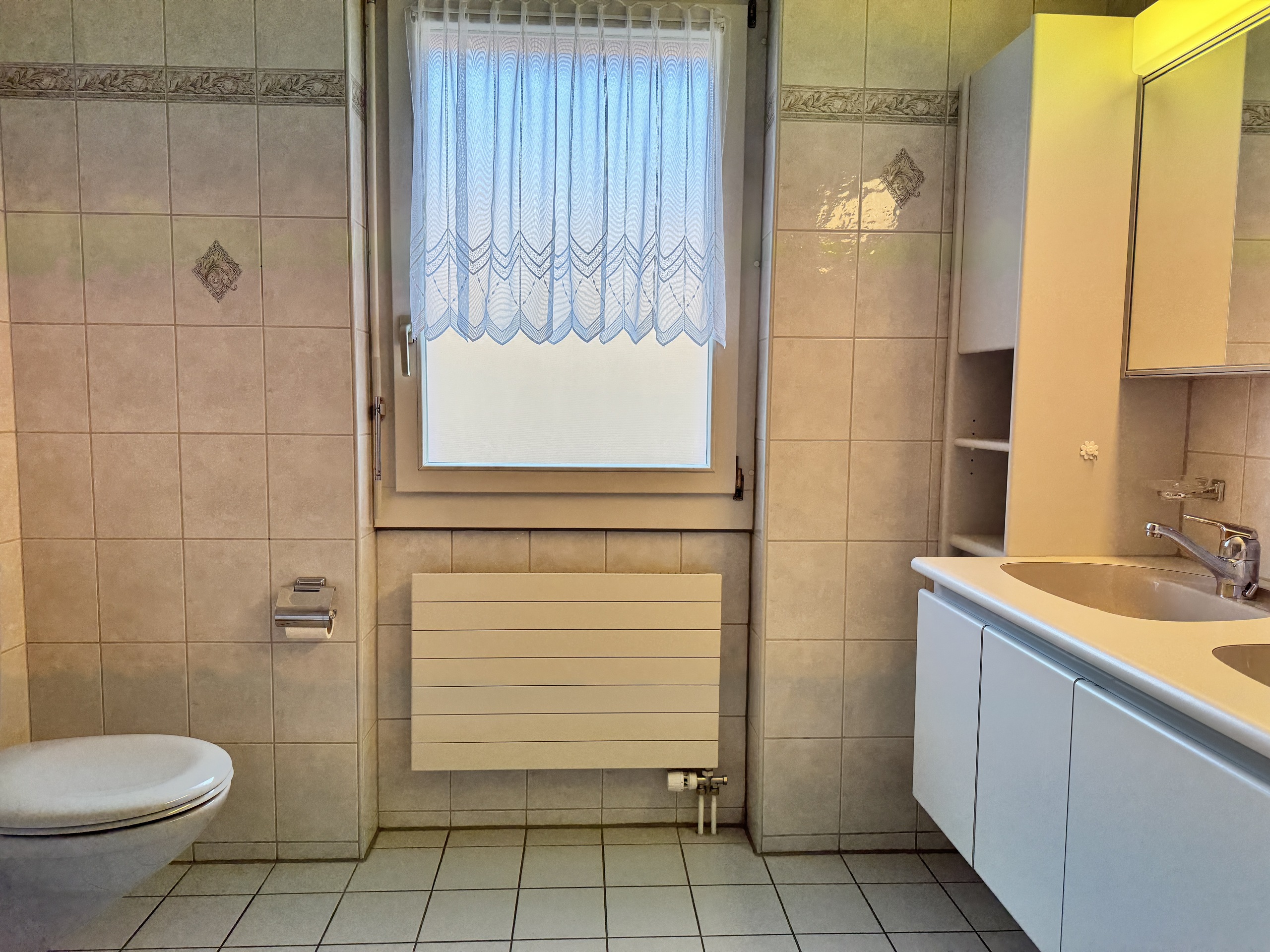 Helles Badezimmer mit Fenster und Waschtisch