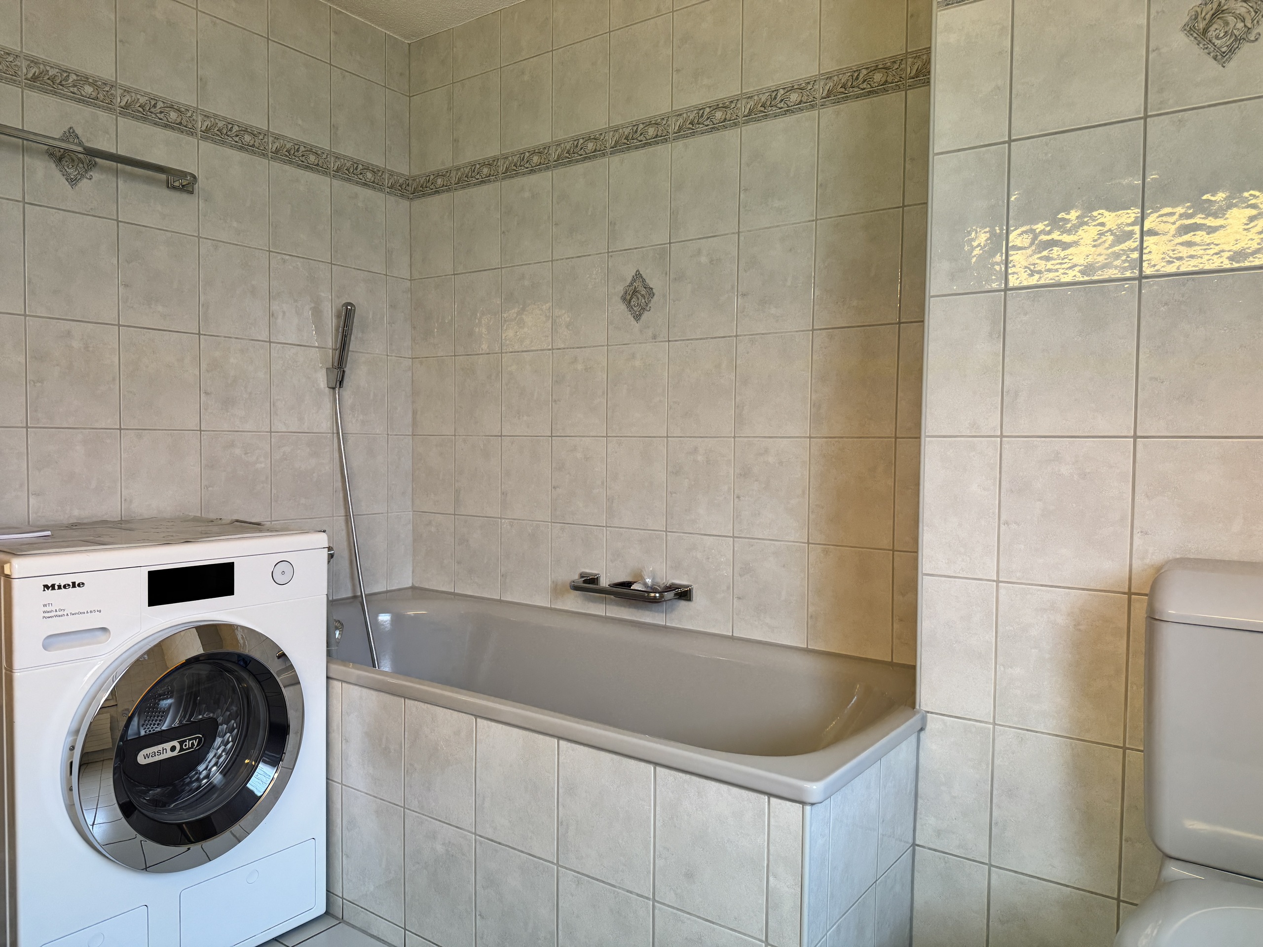 Badezimmer mit Badewanne und Waschmaschine