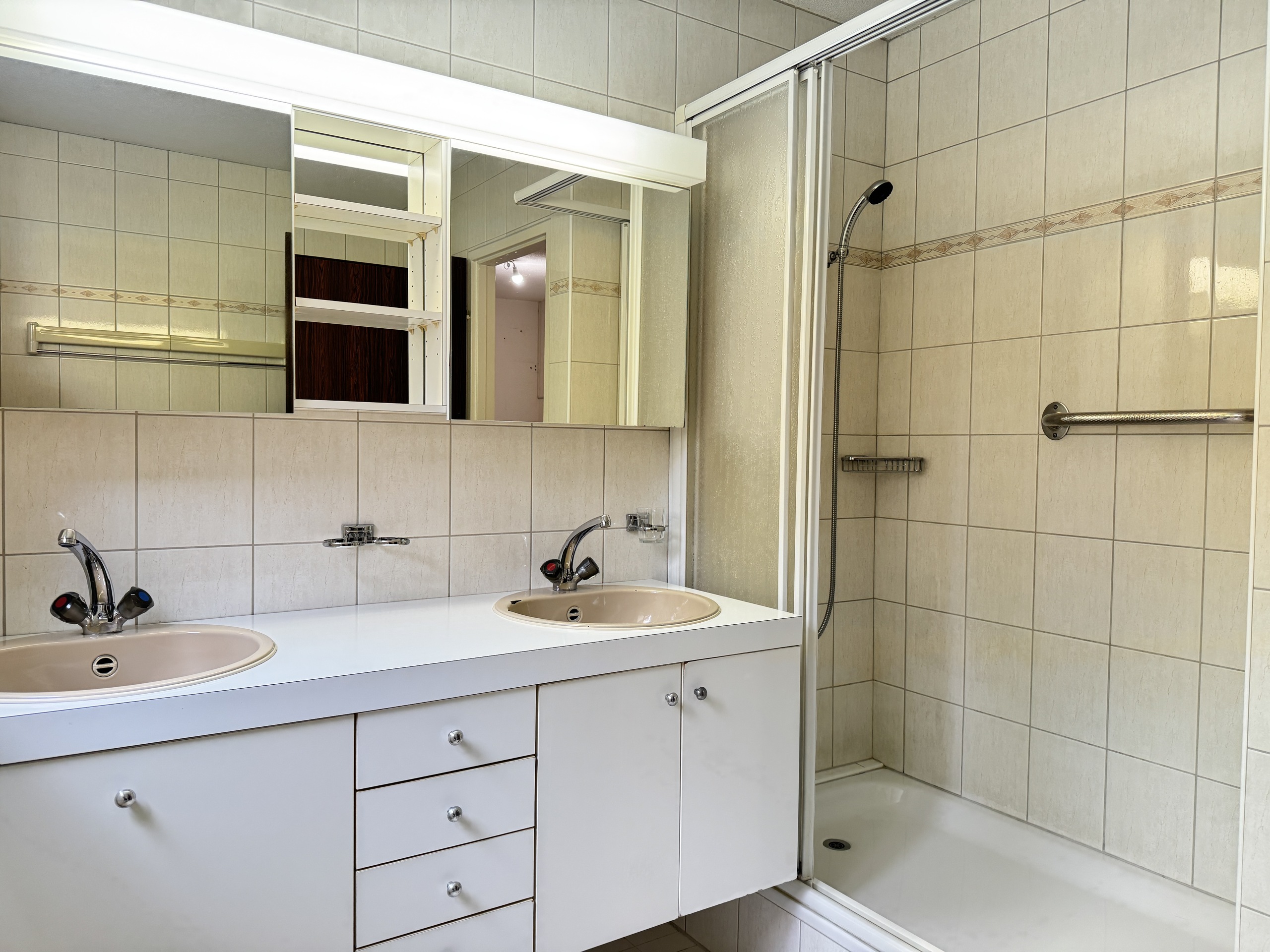 Badezimmer mit Doppelwaschbecken und Dusche