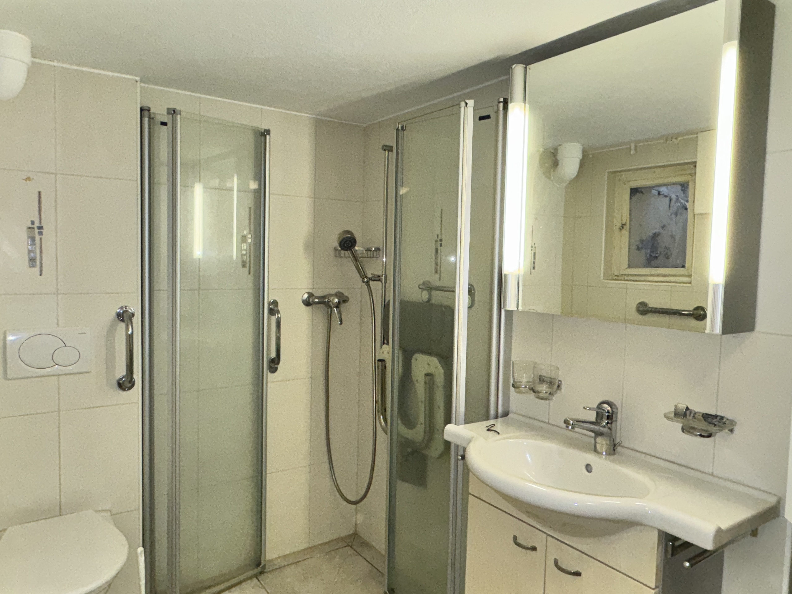 Badezimmer mit Duschkabine und Waschtisch