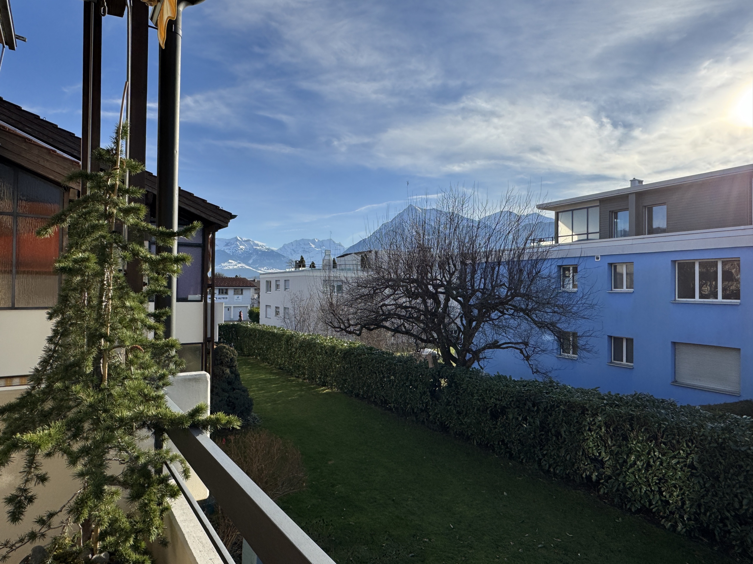 Balkonblick mit Garten und Bergpanorama