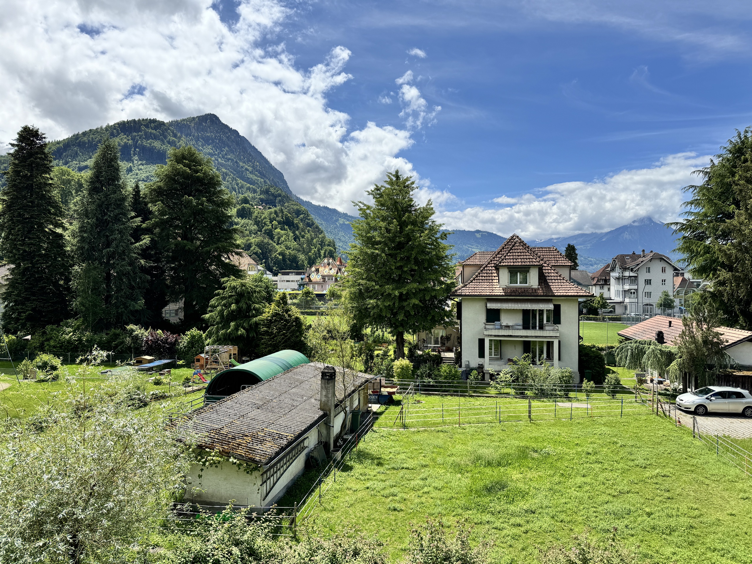 Alpenlandschaft mit Wohnhäusern und Garten