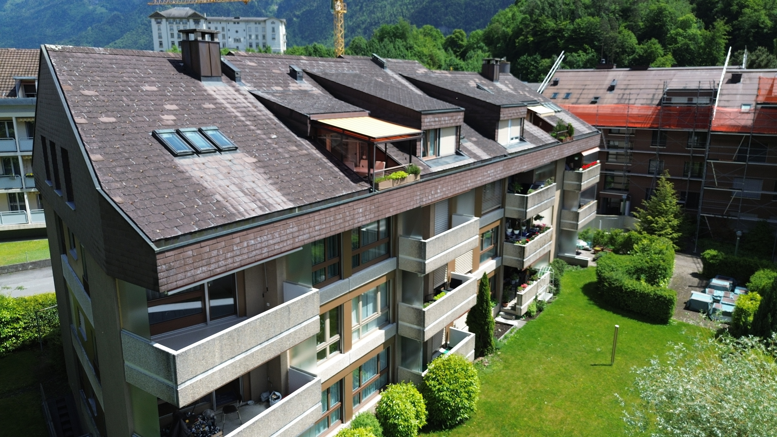 Mehrfamilienhaus mit begrüntem Innenhof und Dachgauben