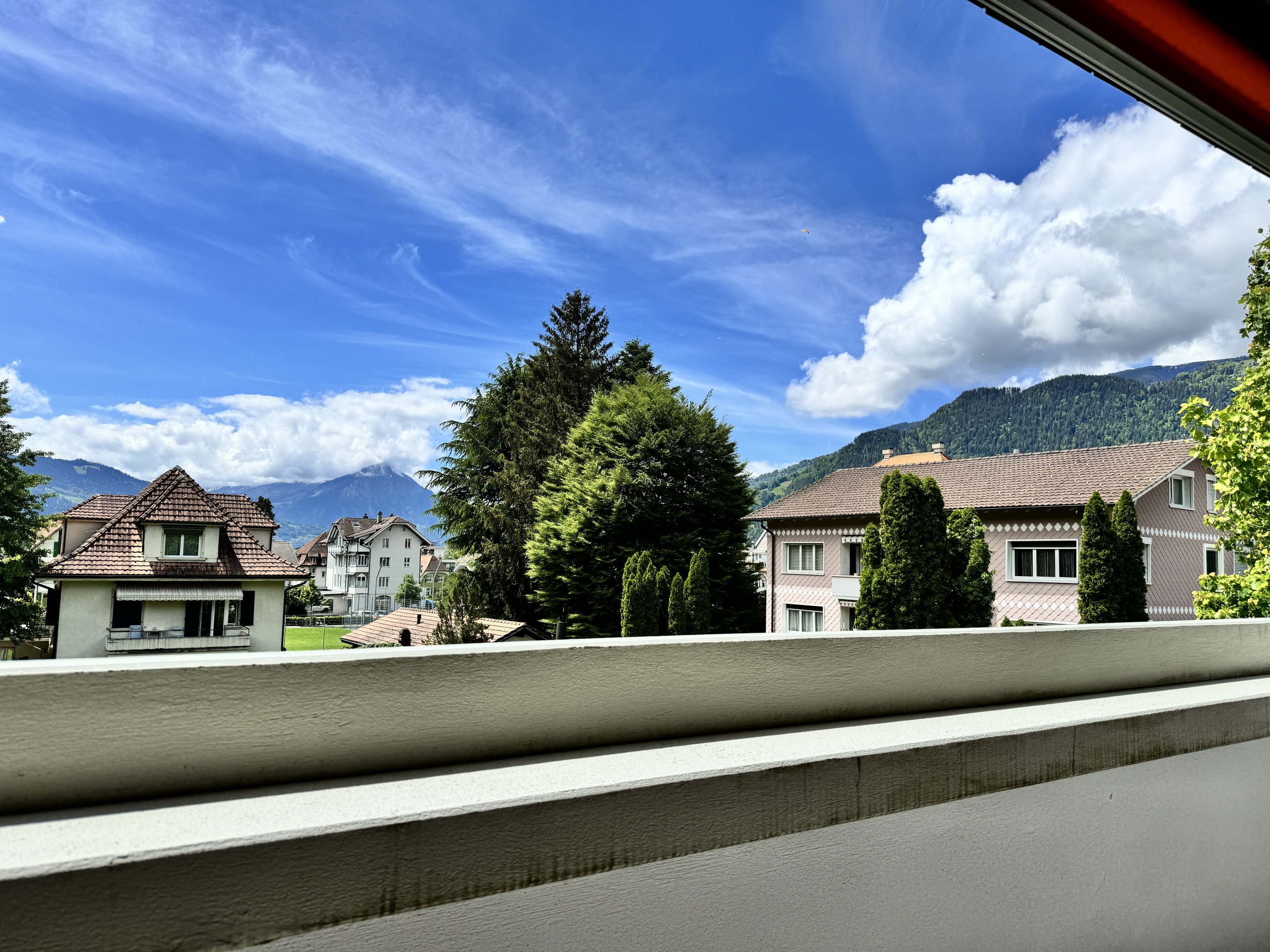 Blick vom Balkon auf Wohnhäuser und Berge