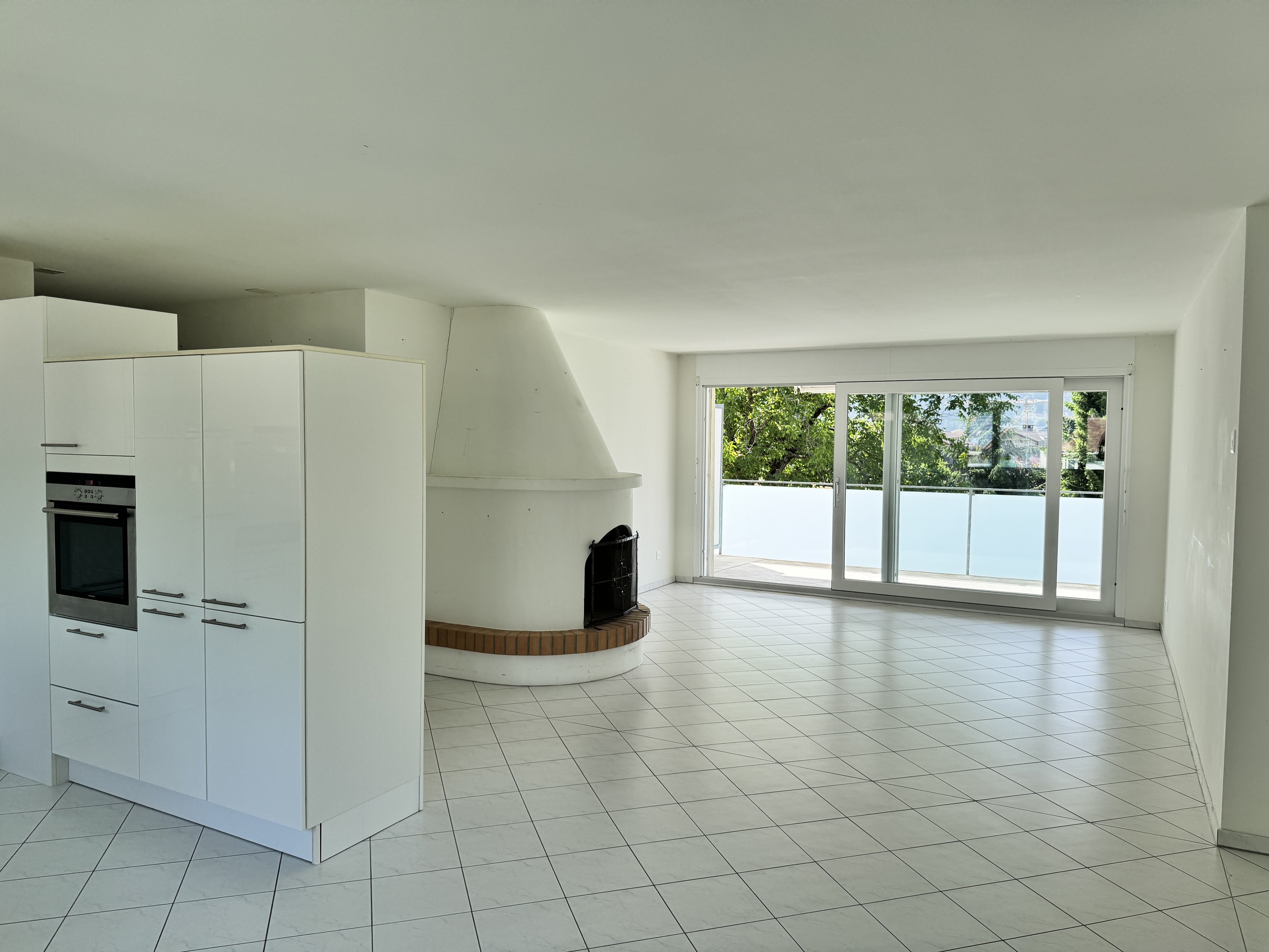 Offener Wohnbereich mit Kamin und Terrasse