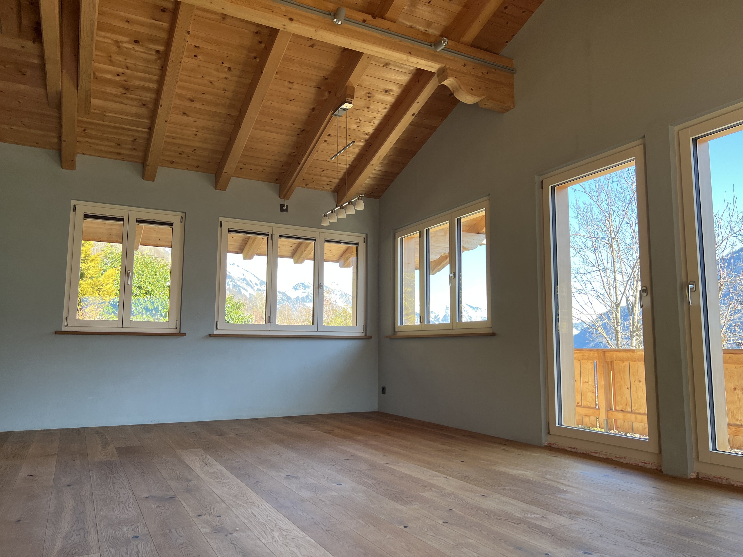 Leerer Wohnraum mit Holzdecke und Bergblick