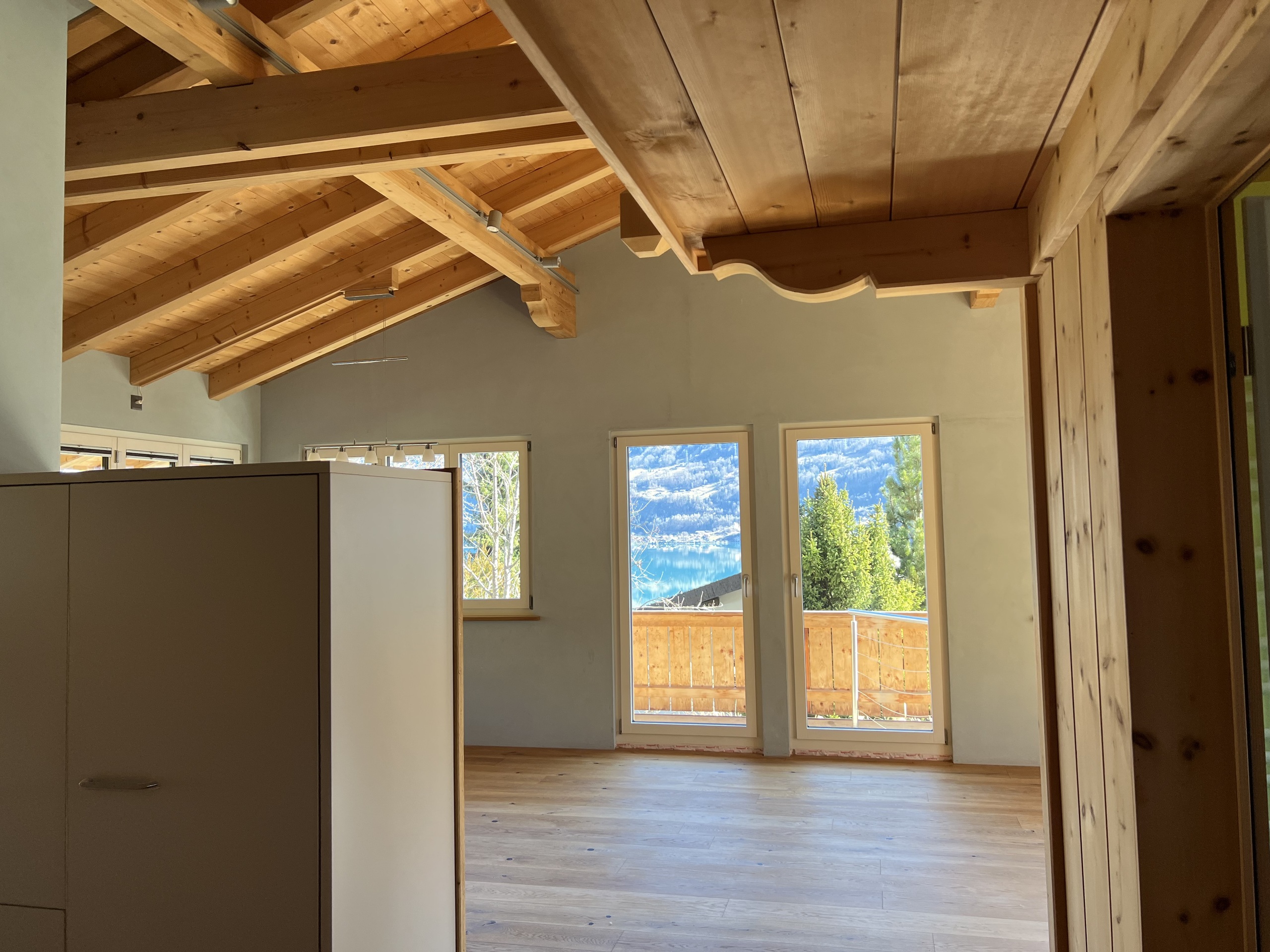 Heller Wohnraum mit Holzdecke und Seeblick
