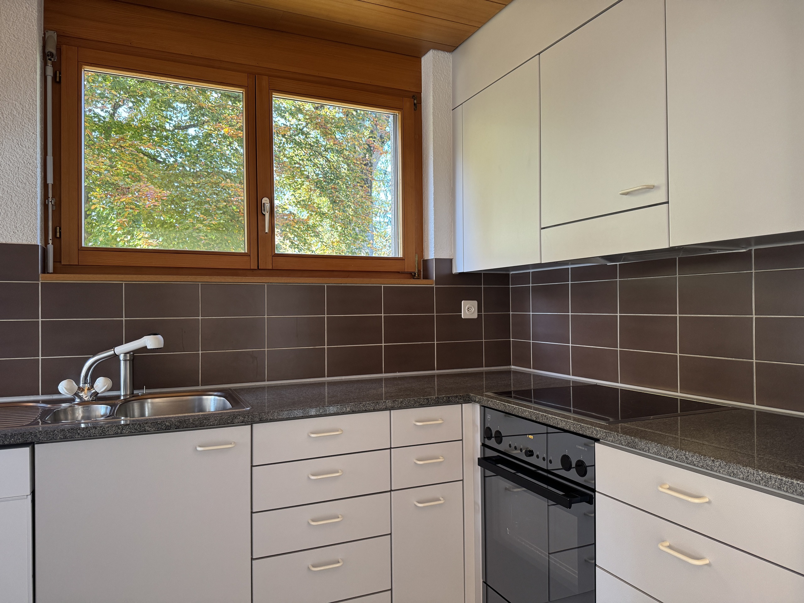 Moderne Küche mit Fensterblick ins Grüne