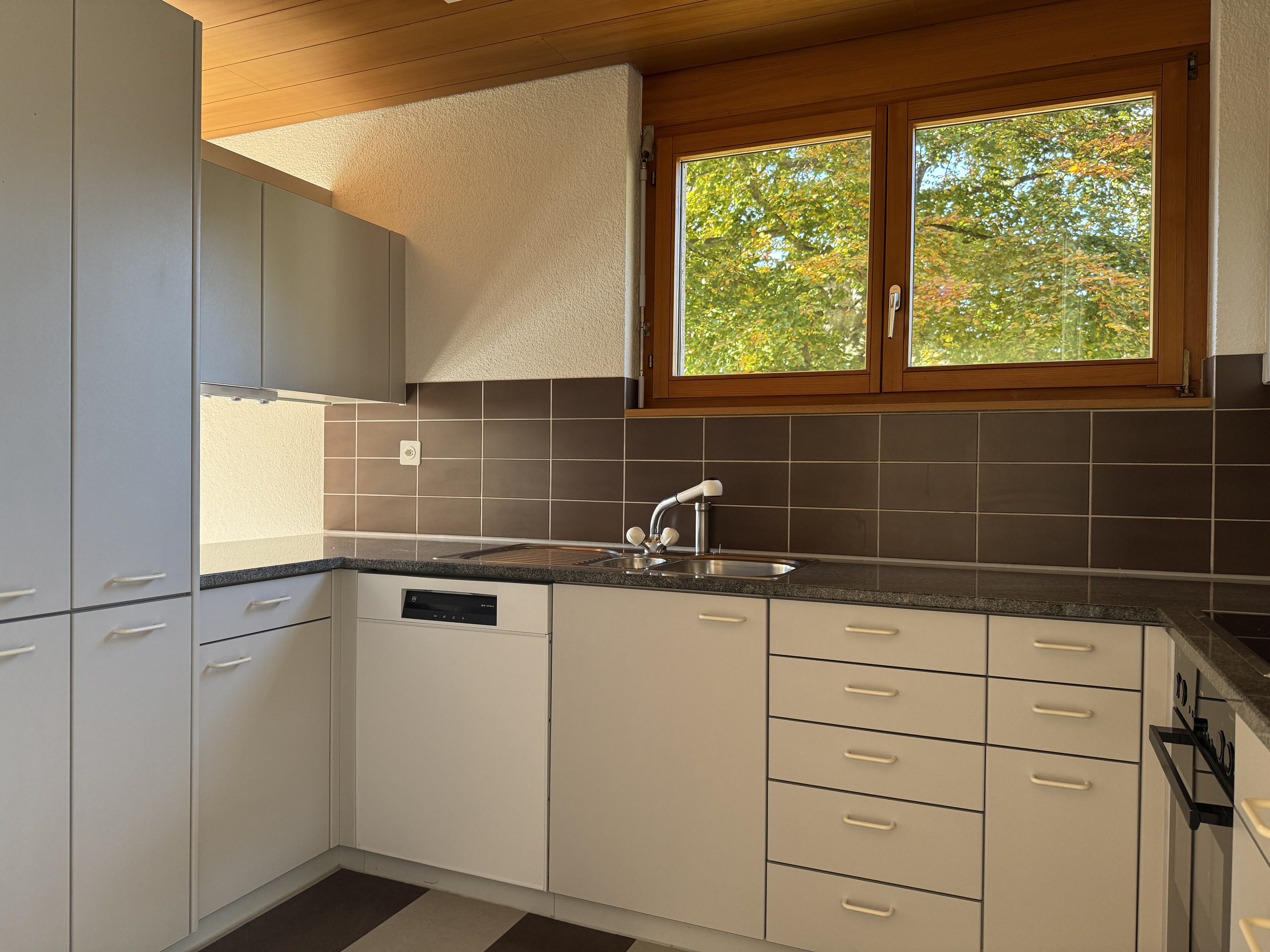Helle Einbauküche mit Holzfenster