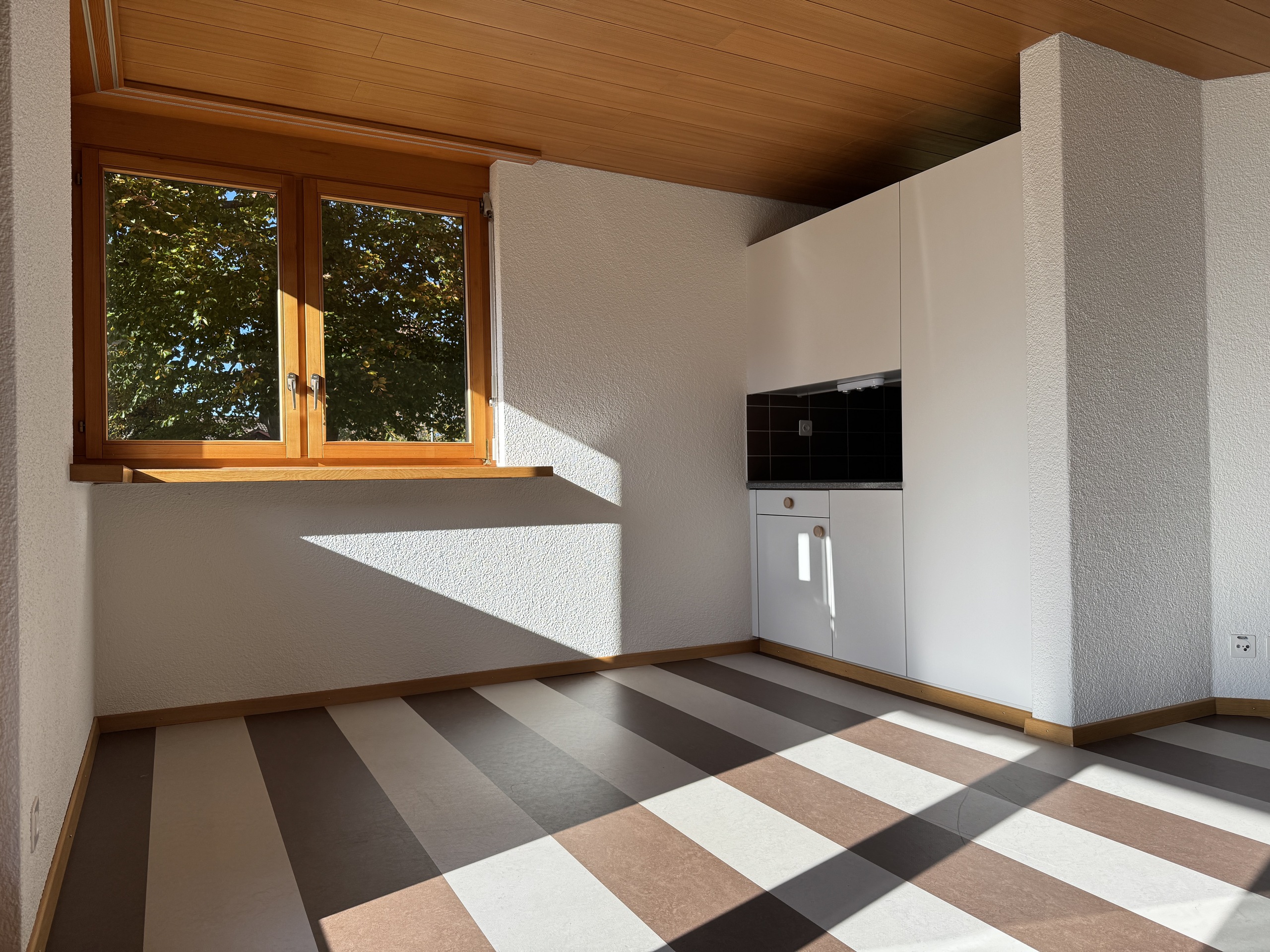 Heller Raum mit Holzfenster und Einbauschränken