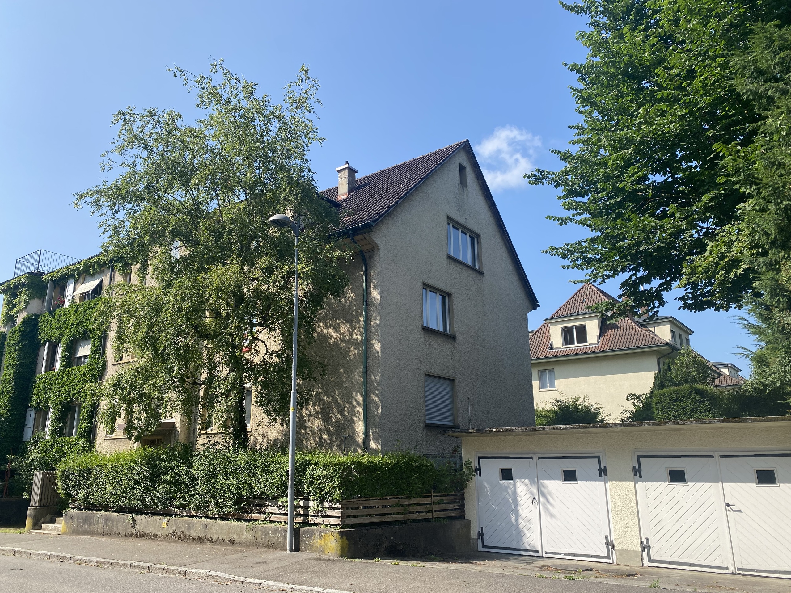 Wohnhaus mit Garagen und begrüntem Umfeld