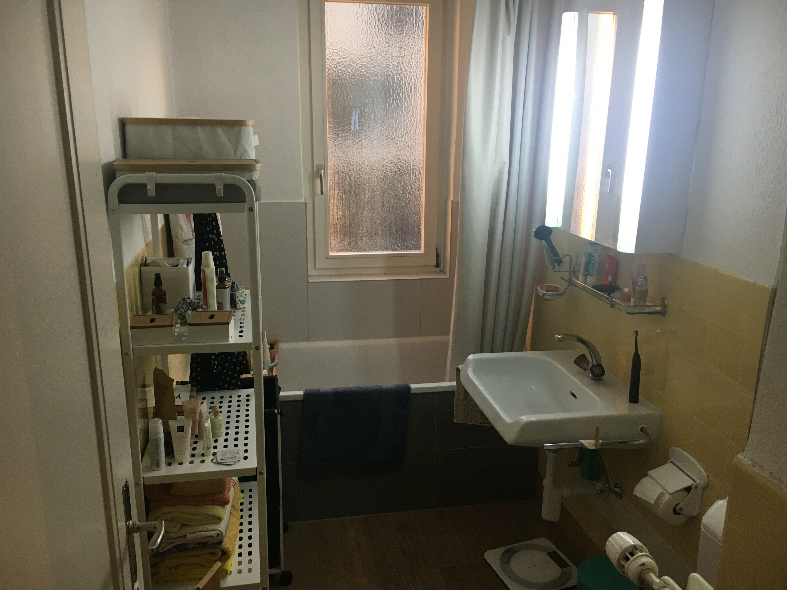 Kleines Badezimmer mit Badewanne und Waschbecken