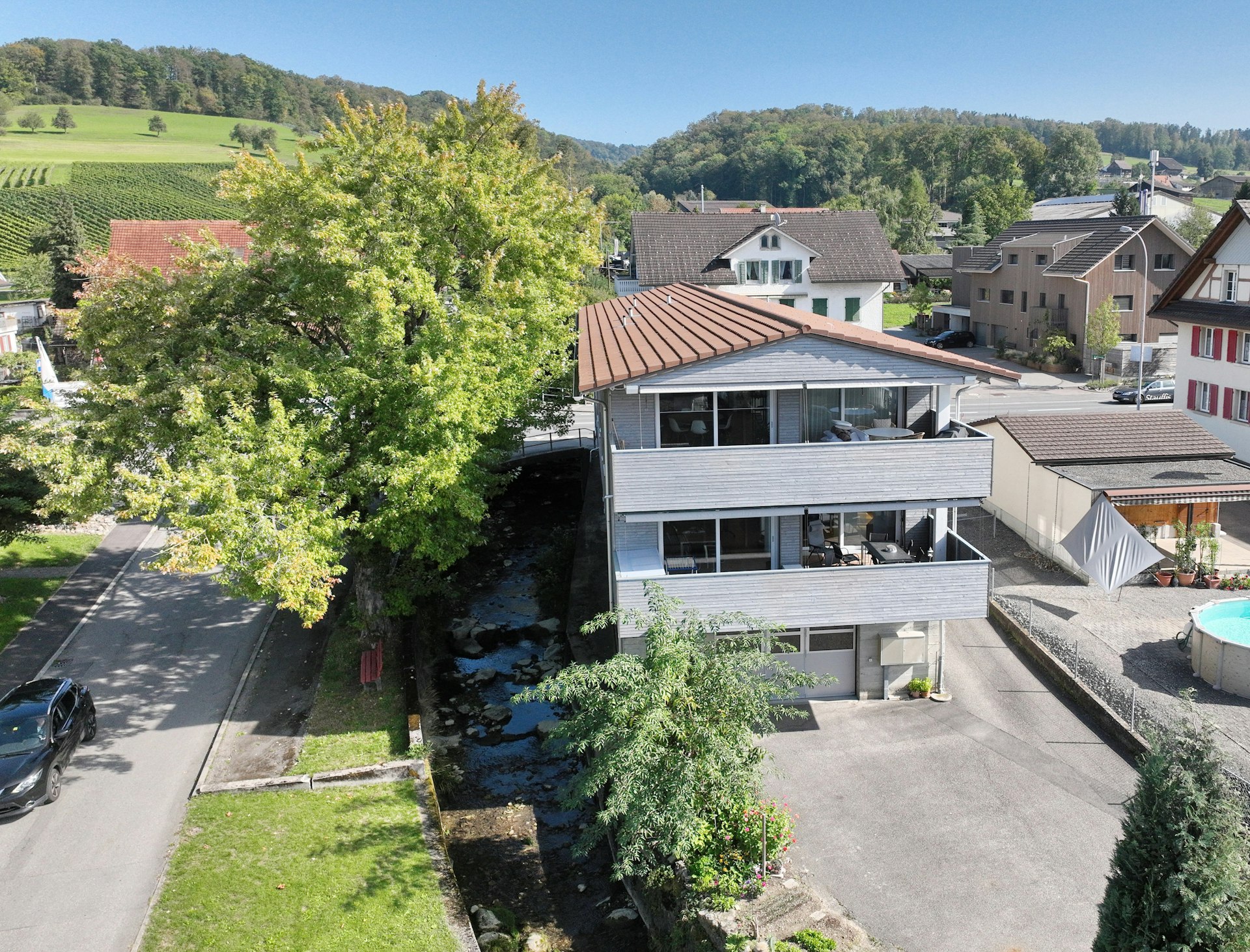 Wohnhaus mit Flachdach und Balkon in grüner Umgebung