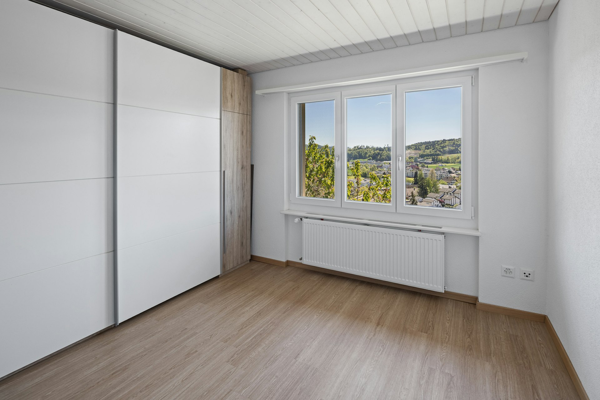 Helles Schlafzimmer mit Einbauschrank und Ausblick