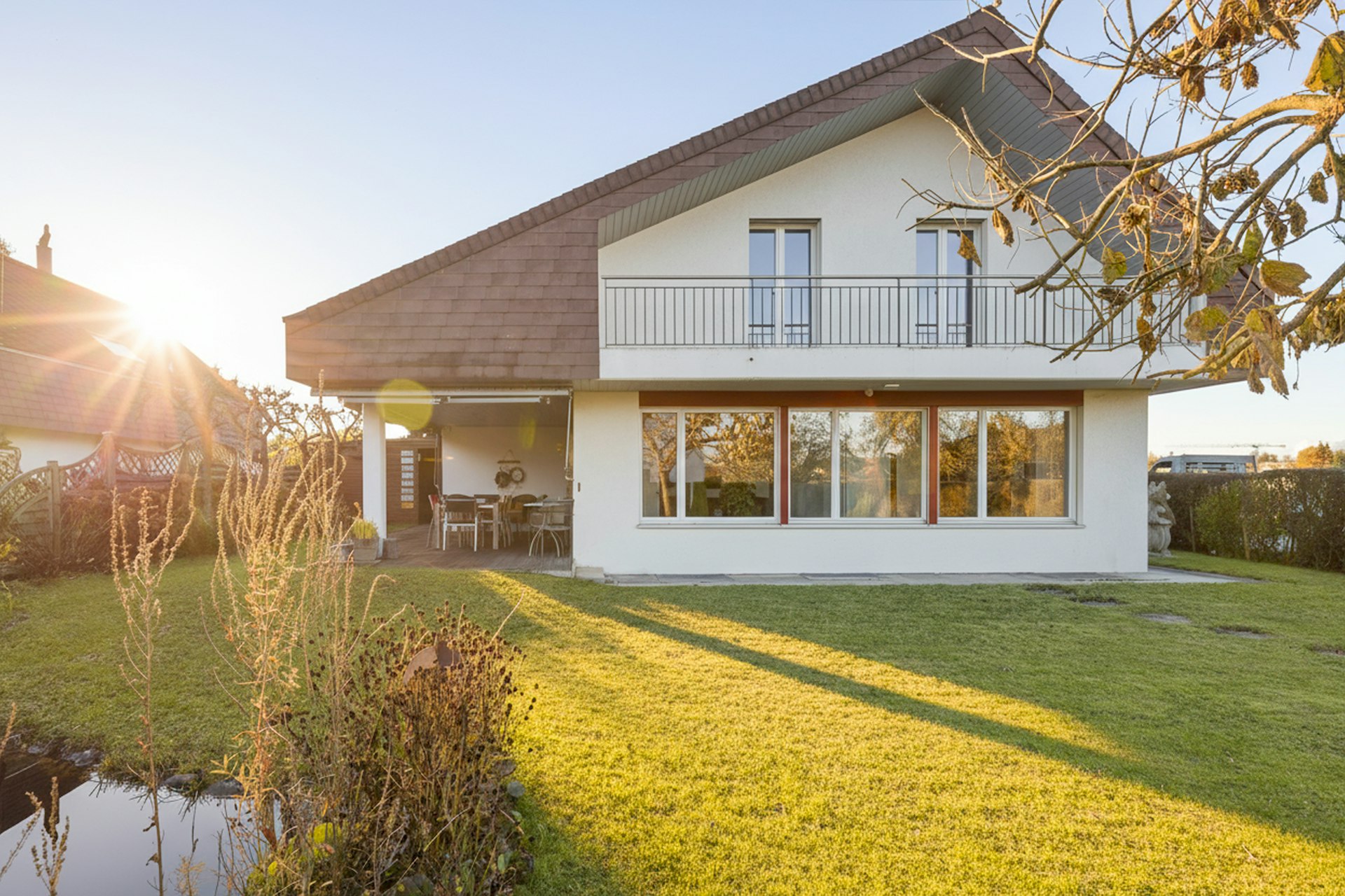 Einfamilienhaus mit Garten und Balkon im Abendlicht